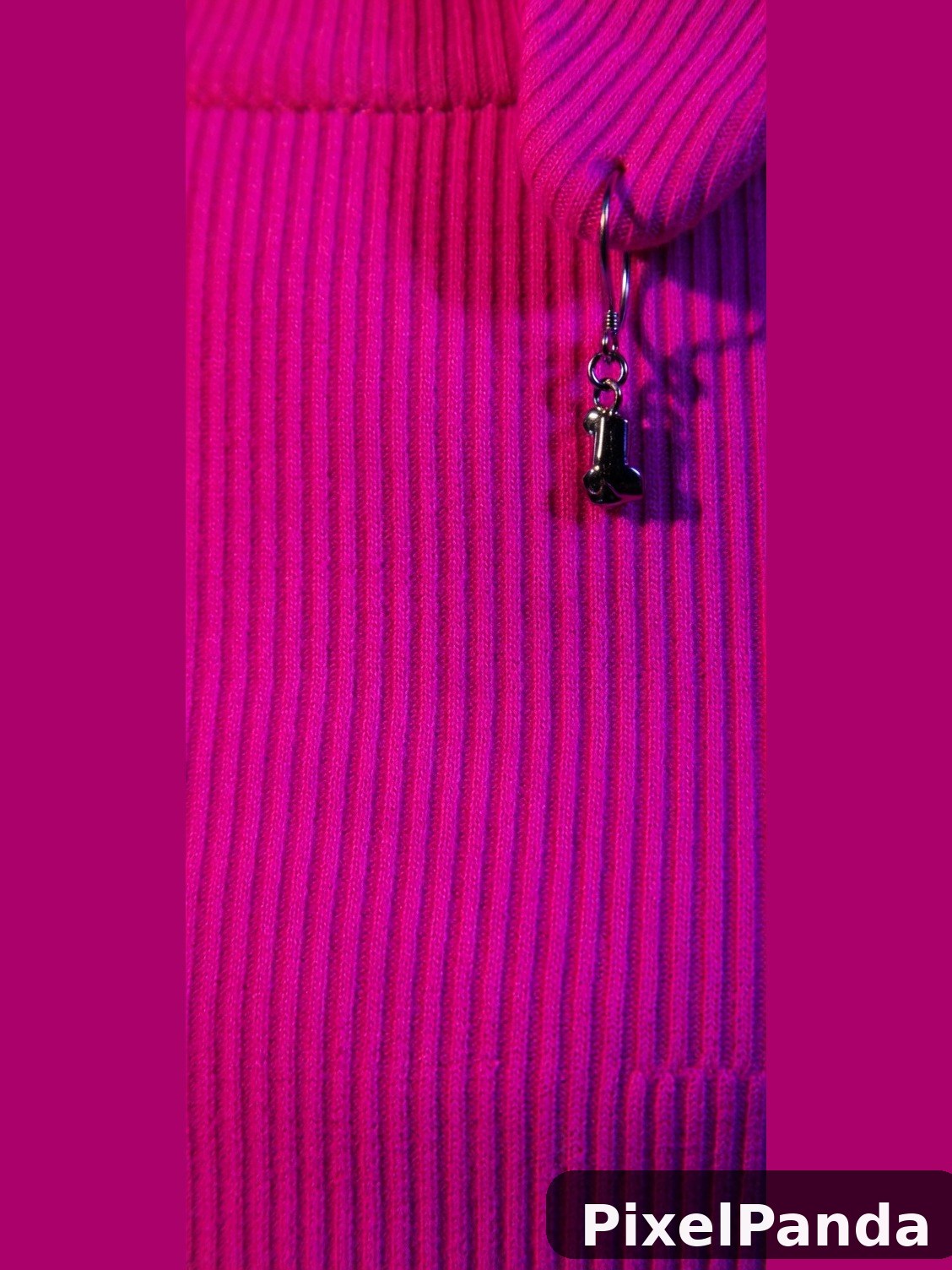 Person in ribbed magenta sweater with dangling silver earring