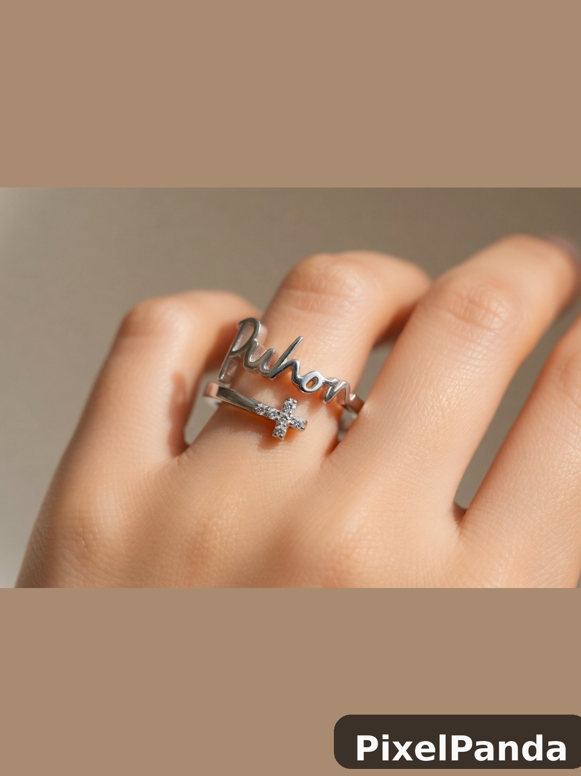 Silver ring with script text and cross charm on hand