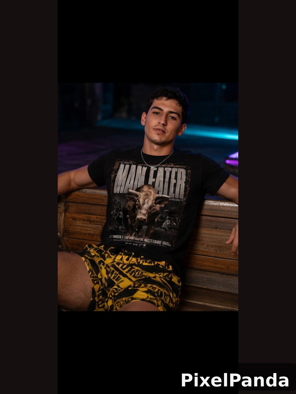 Man in graphic tee and yellow patterned shorts on wooden bench