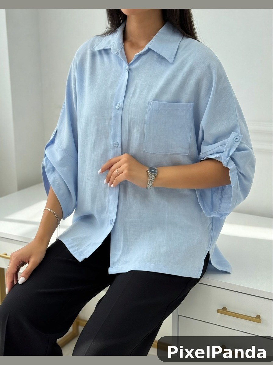 Person in light blue button-up shirt sitting on white surface