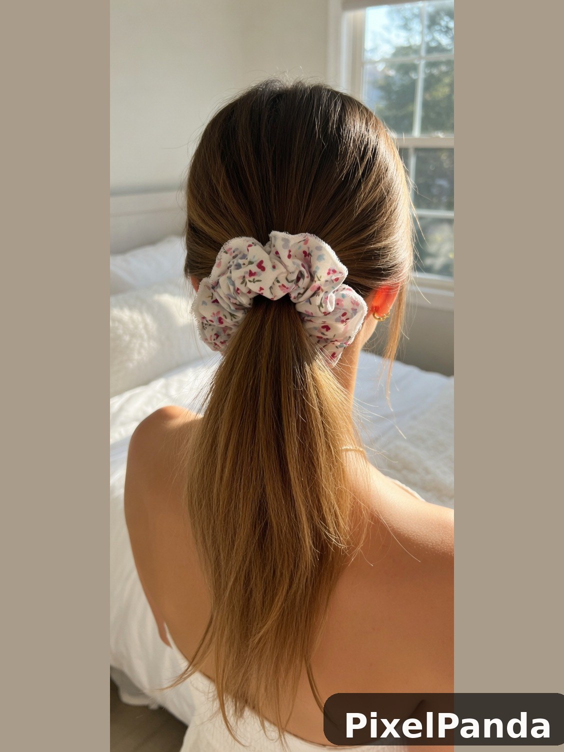 Long brown hair with floral scrunchie, back view by window