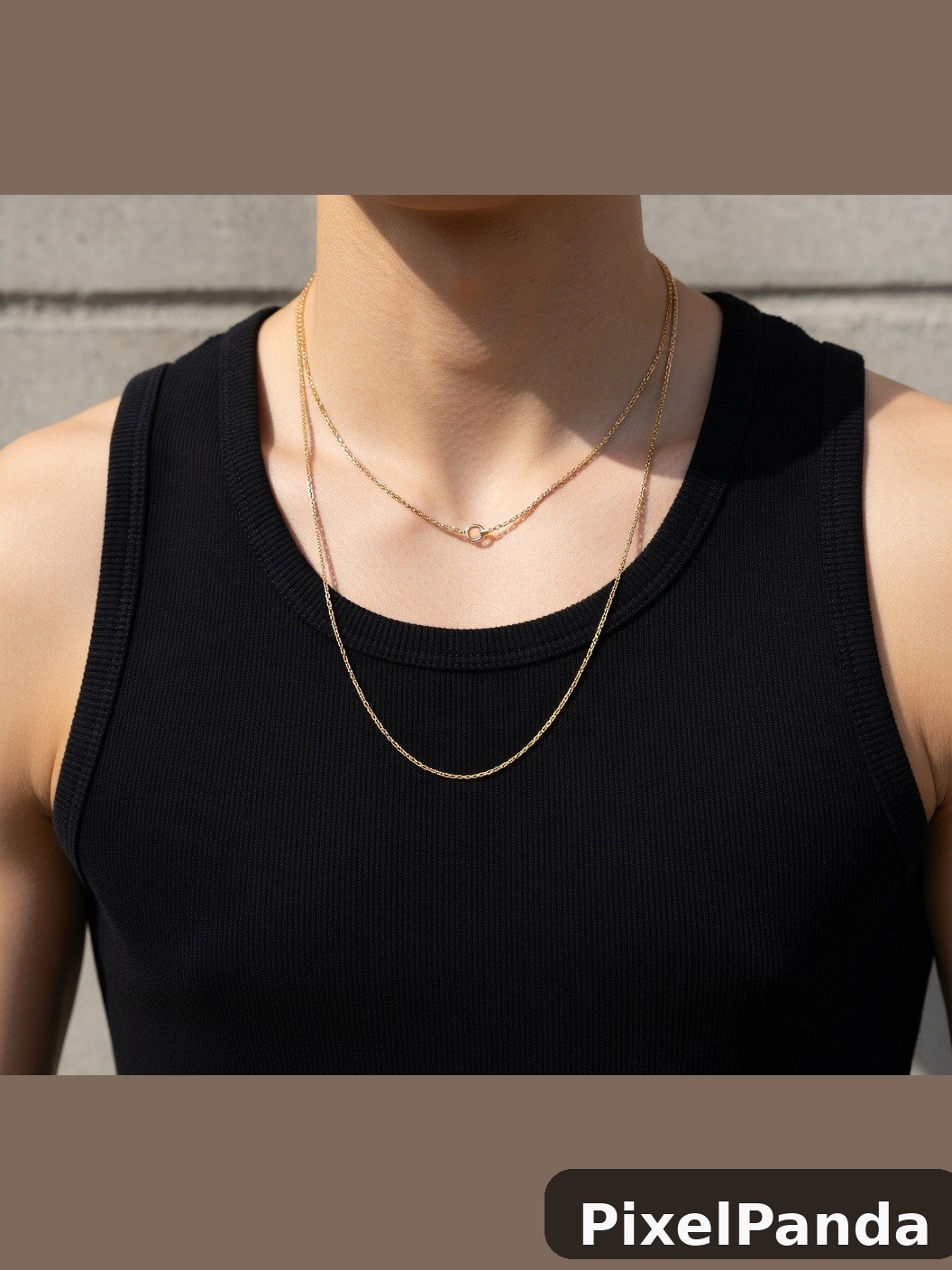 Person wearing layered gold chain necklaces with black ribbed tank top