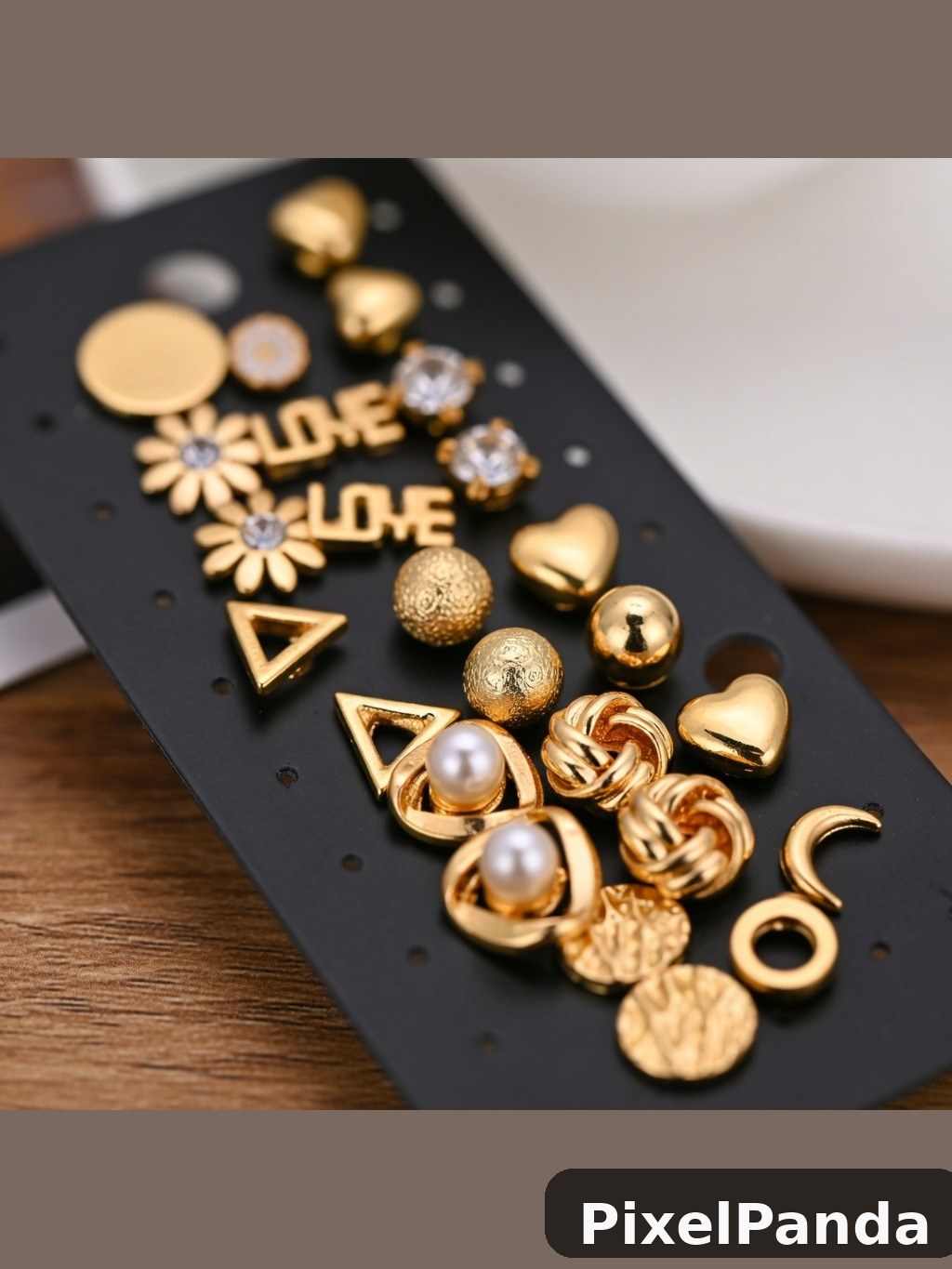 Gold charm earrings and pendants on black display card