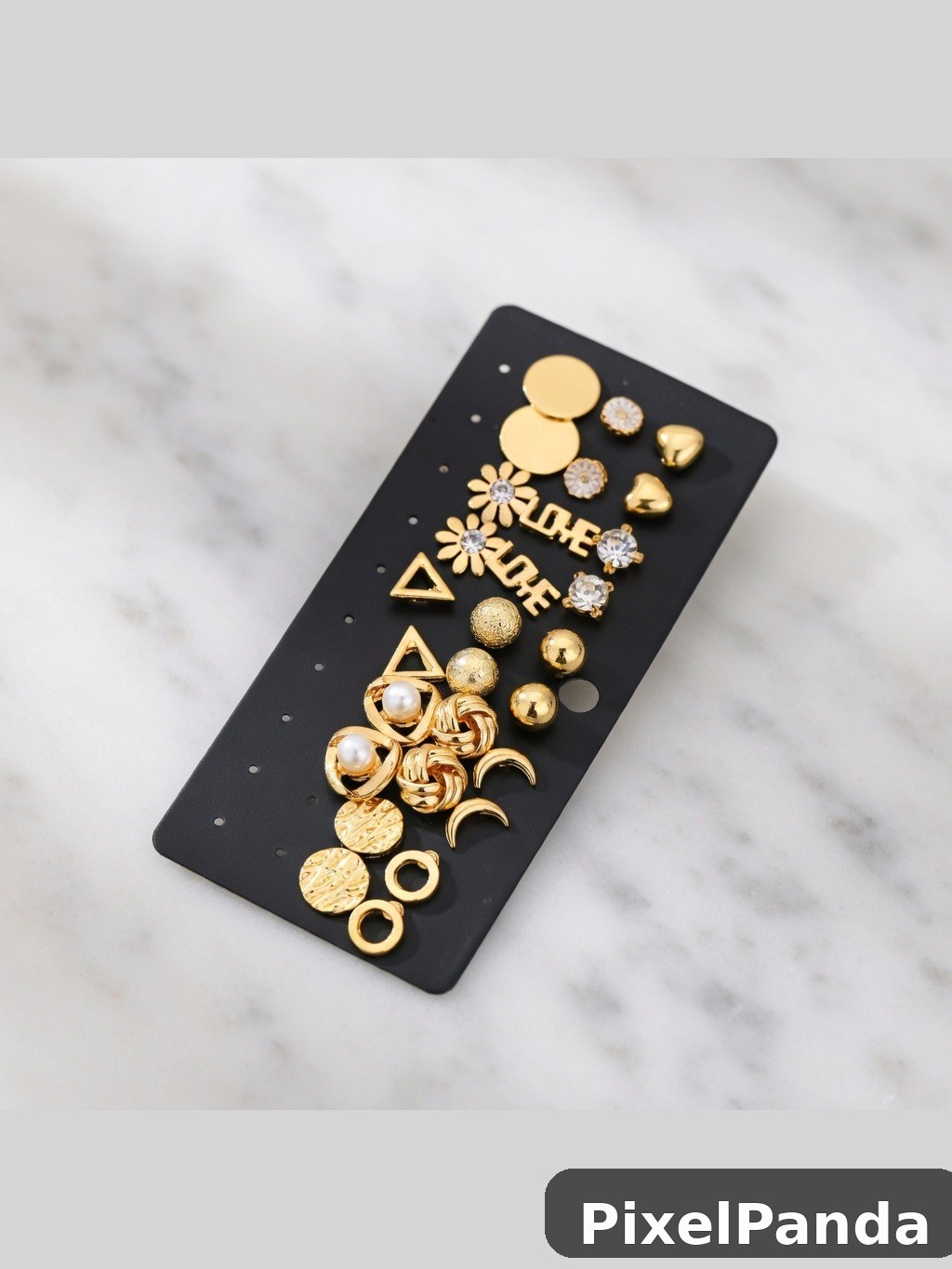 Gold jewelry charms and rhinestone accents on black display card