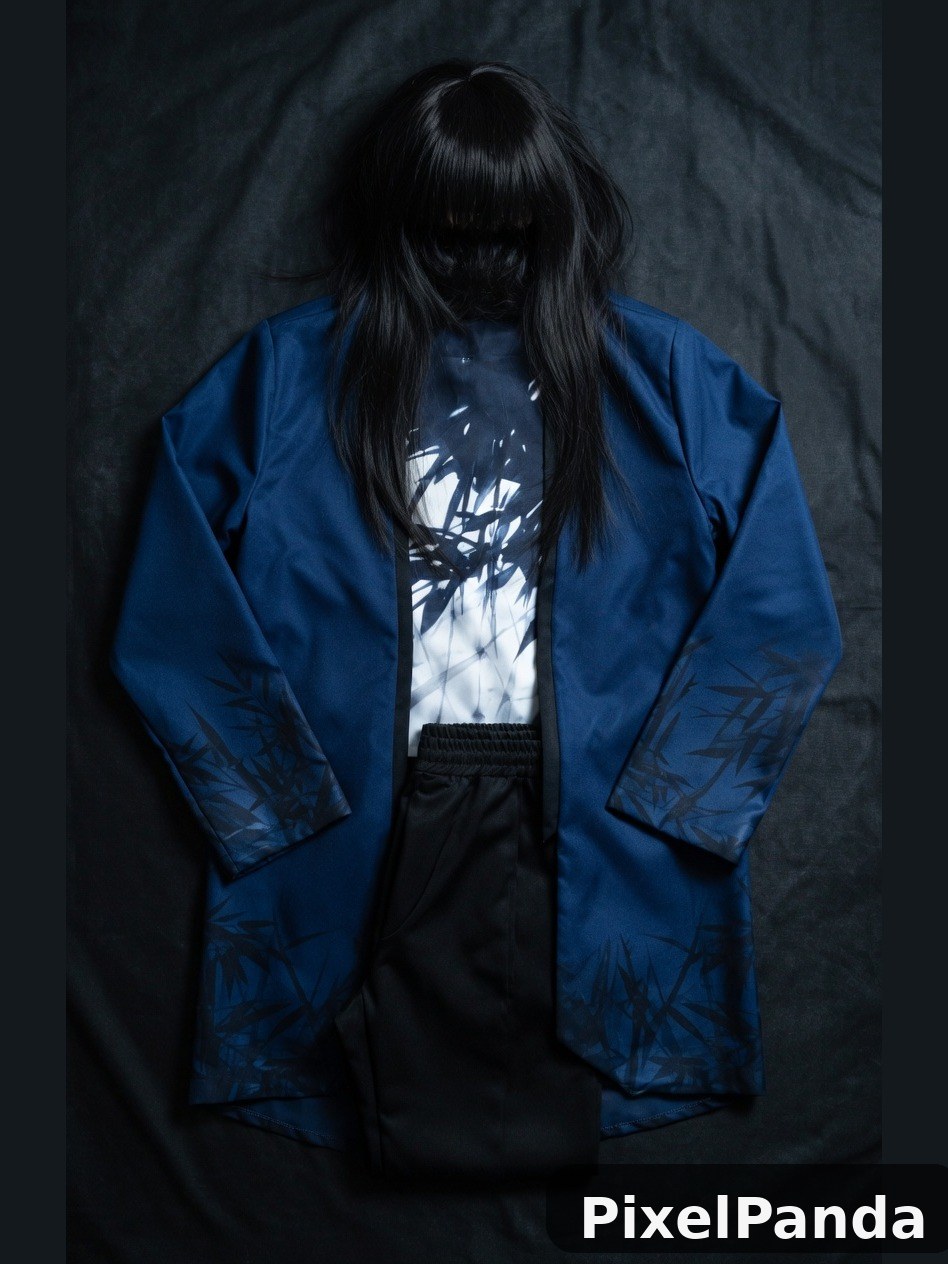 Person with long black hair wearing blue blazer against dark backdrop