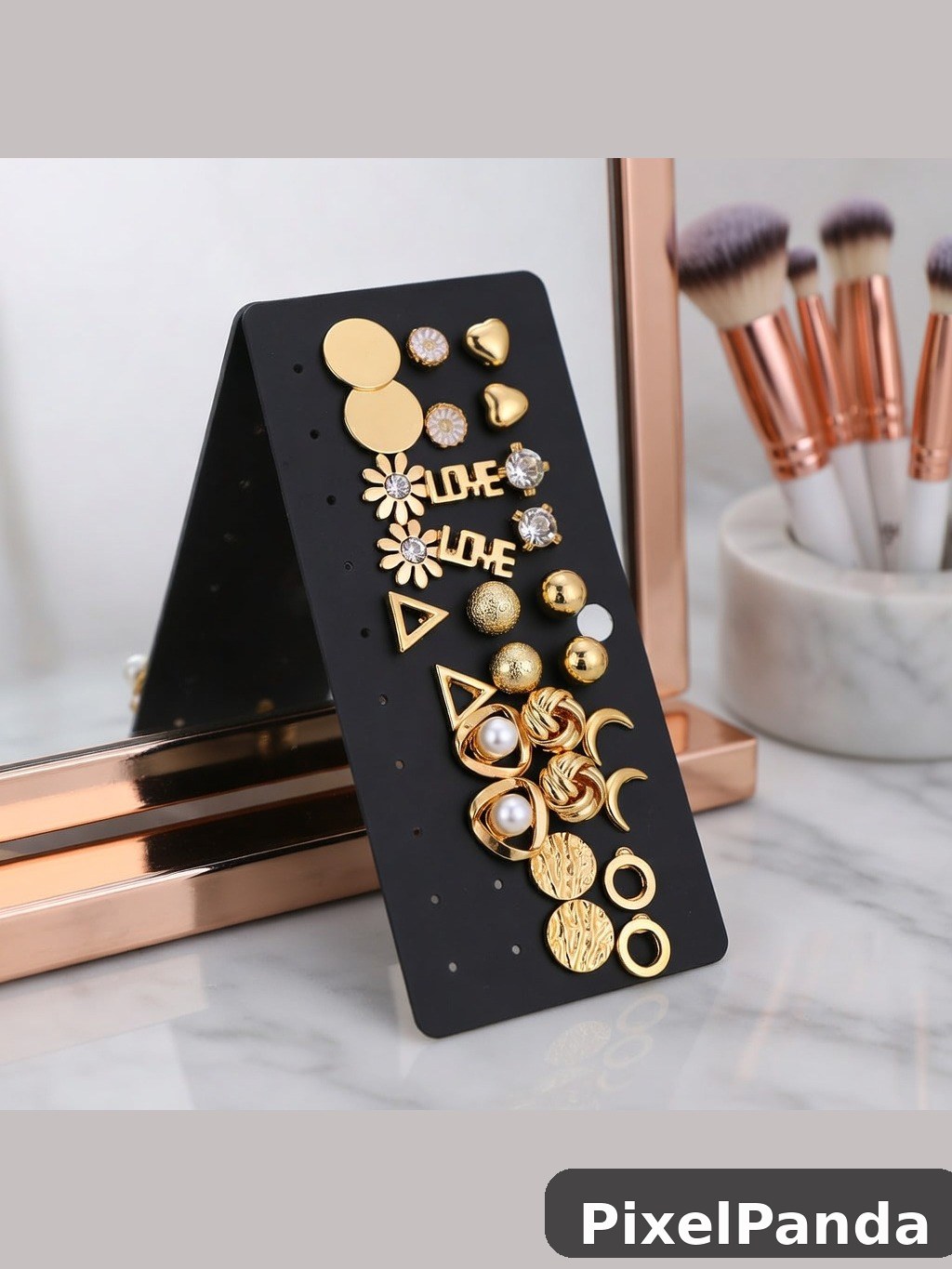 Black earring display card with gold and pearl stud designs