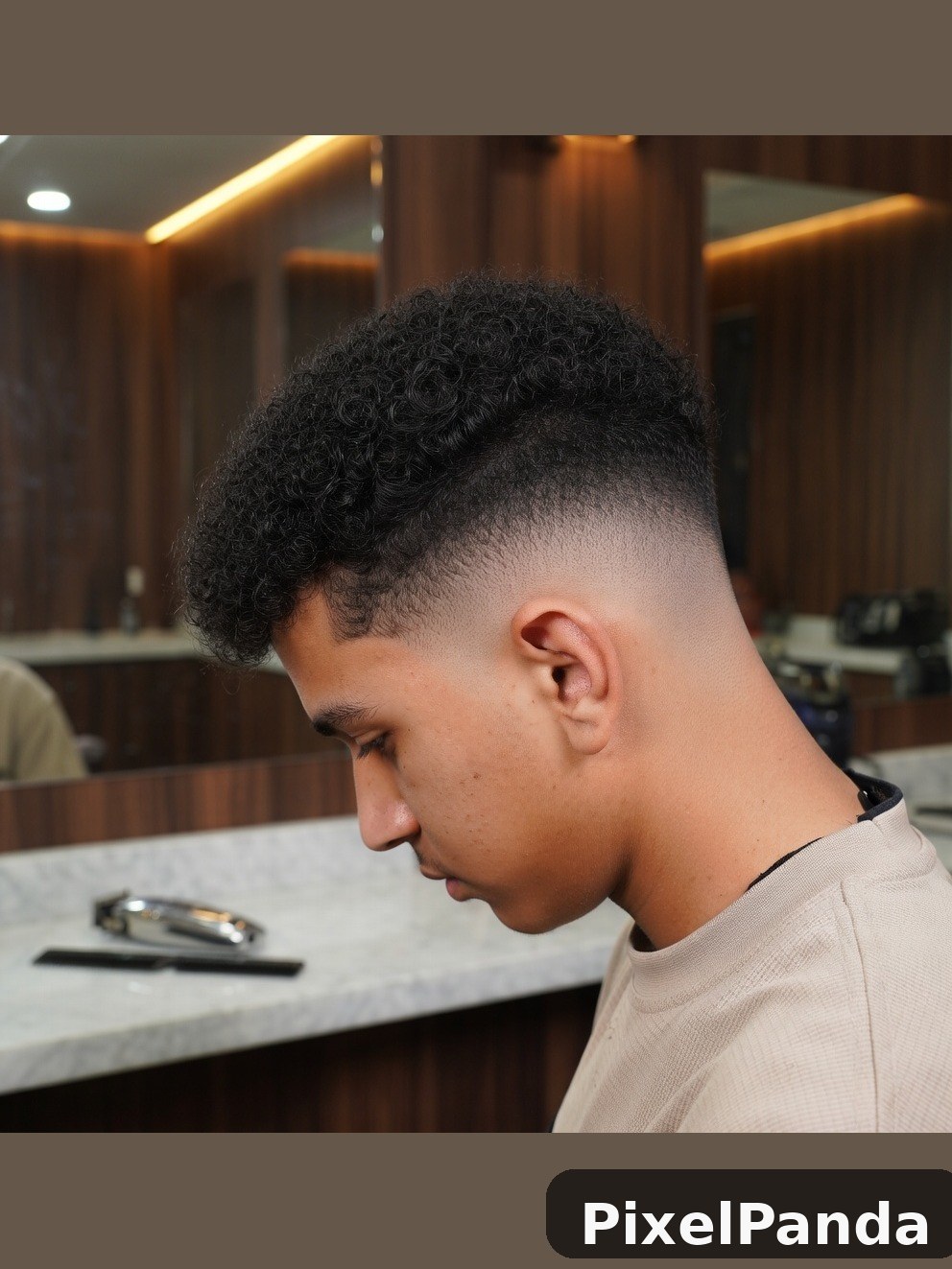 Person with textured curly top fade haircut in modern salon