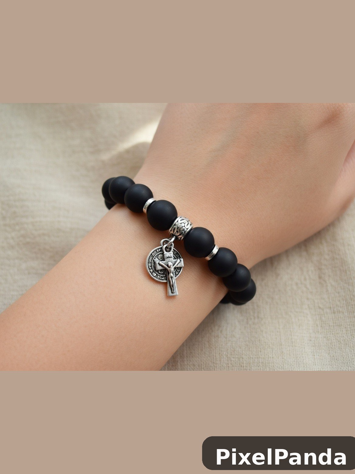 Black bead bracelet with silver Celtic cross charm on wrist