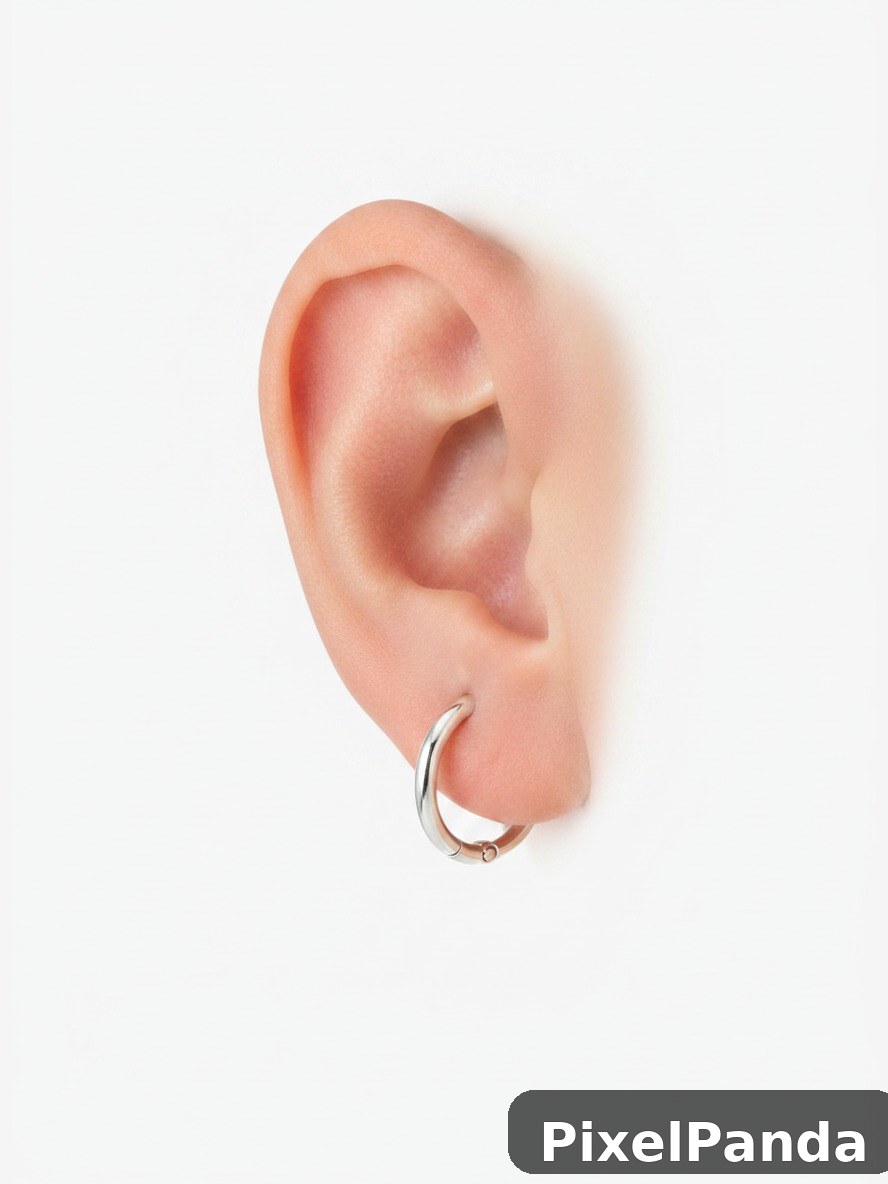 Ear with silver hoop earring against white background
