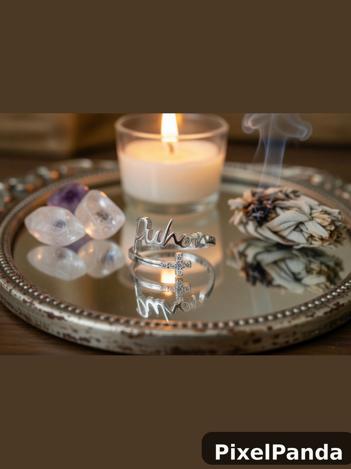 Silver rings with cross detail on ornate tray with candle and crystals