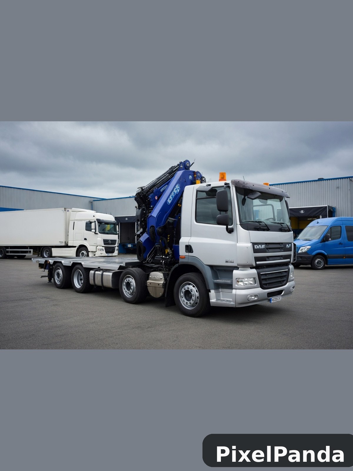 White DAF truck with blue hydraulic crane in industrial yard