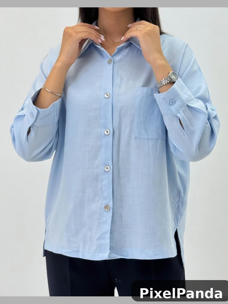 Person in light blue button-up shirt with rolled sleeves