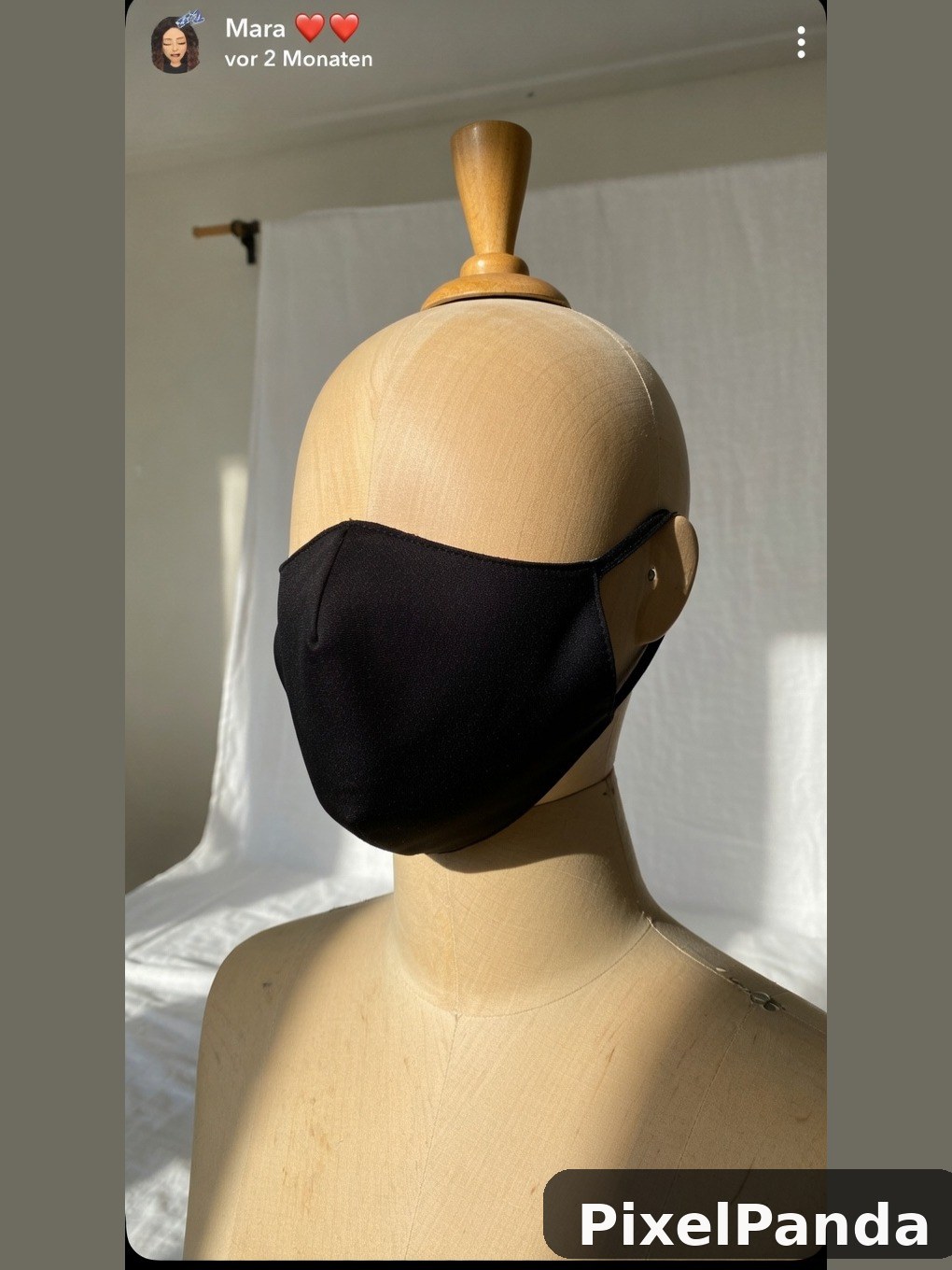 Black fabric face mask on wooden mannequin head