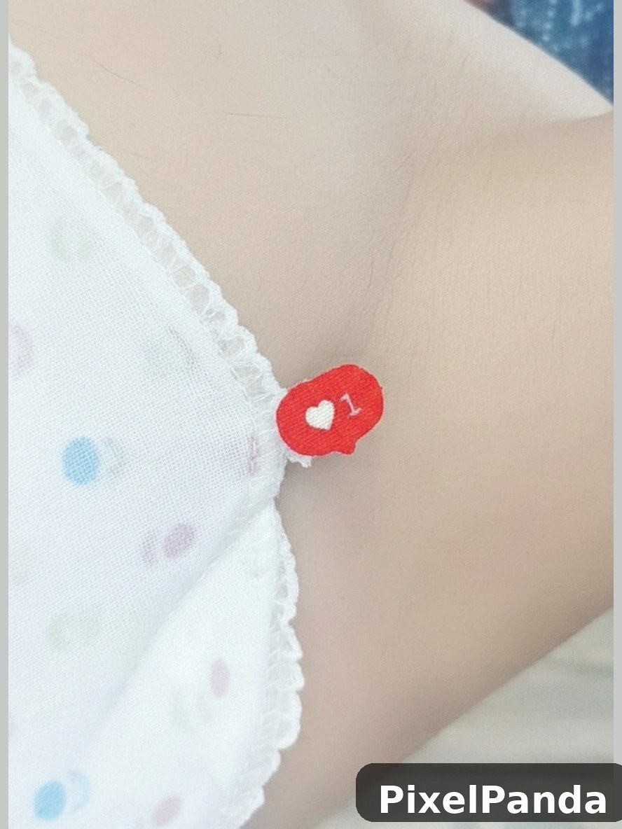 Red heart-shaped social media like badge on white polka dot fabric