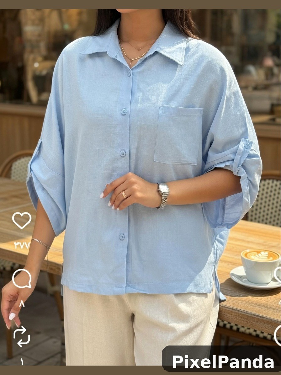 Person in light blue button-up shirt at cafe table with coffee