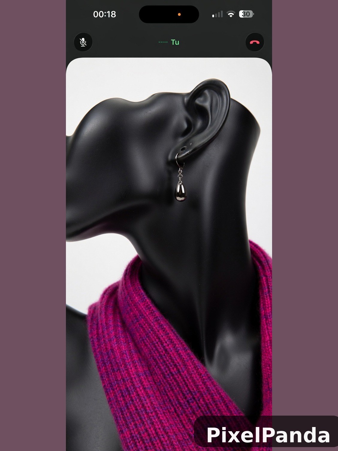 Silver drop earring on black mannequin neck with magenta sweater