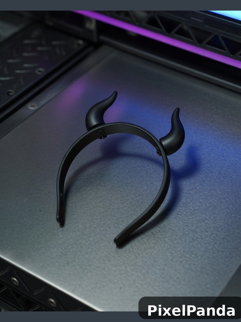 Black horned headband with curved horns on metallic surface