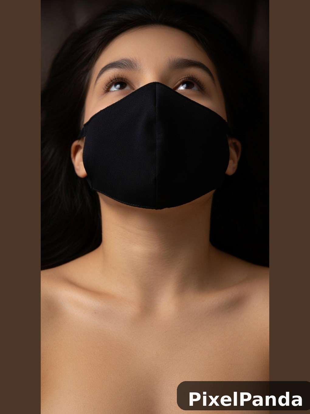 Person wearing black fabric face mask looking upward