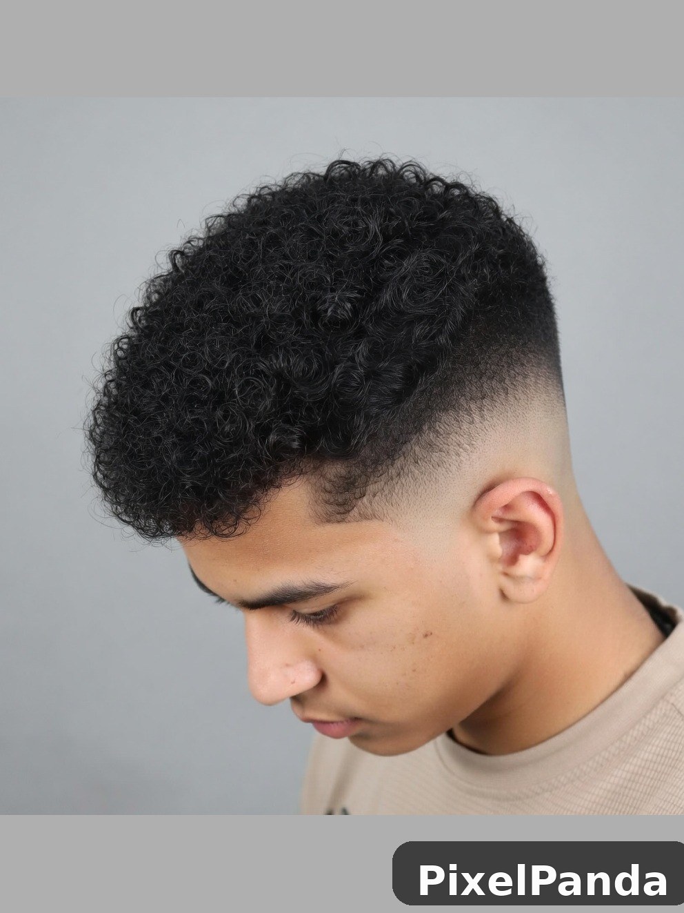 Person with textured curly hair and faded undercut