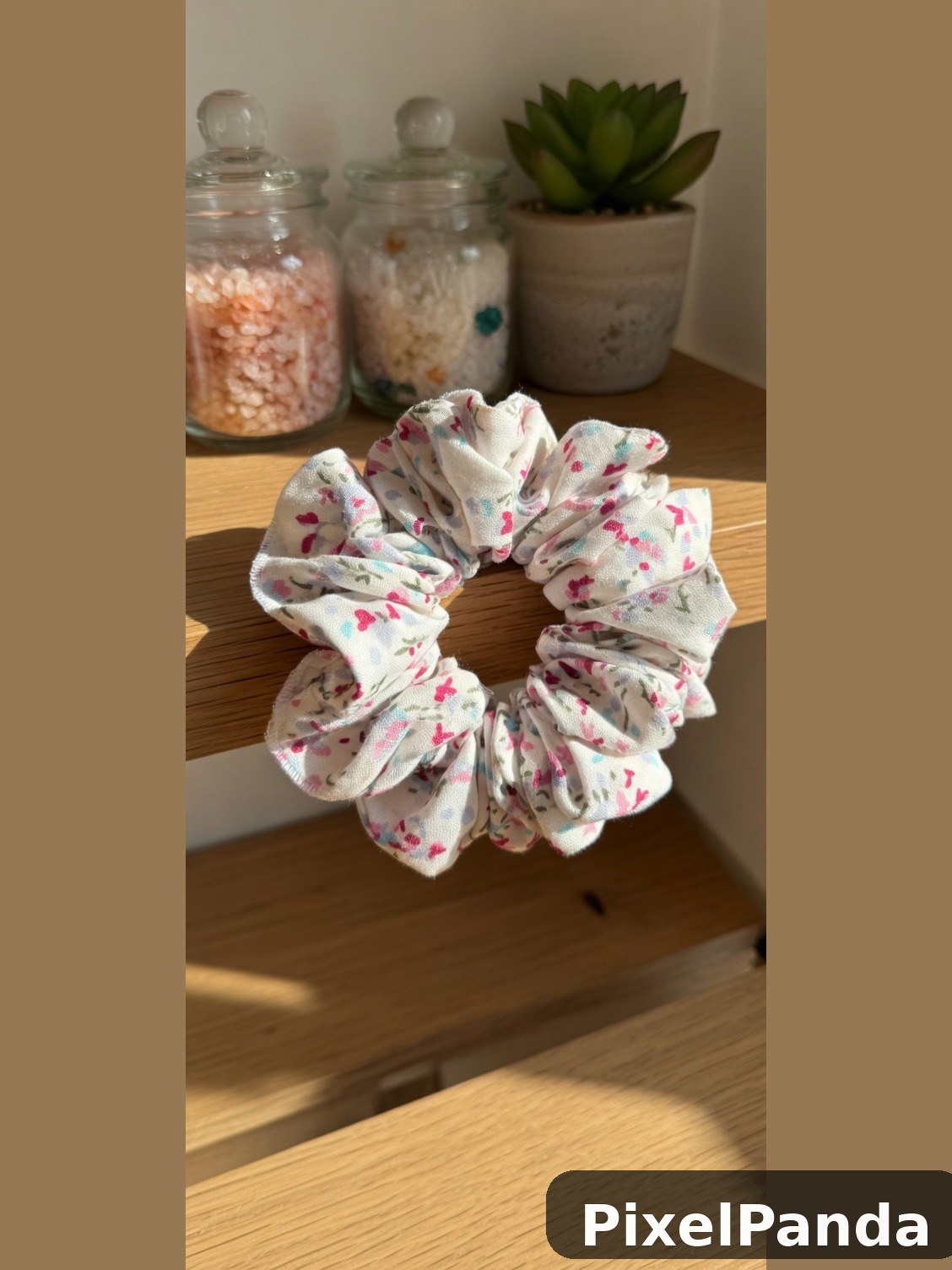 Floral print fabric scrunchie on wooden shelf with home decor