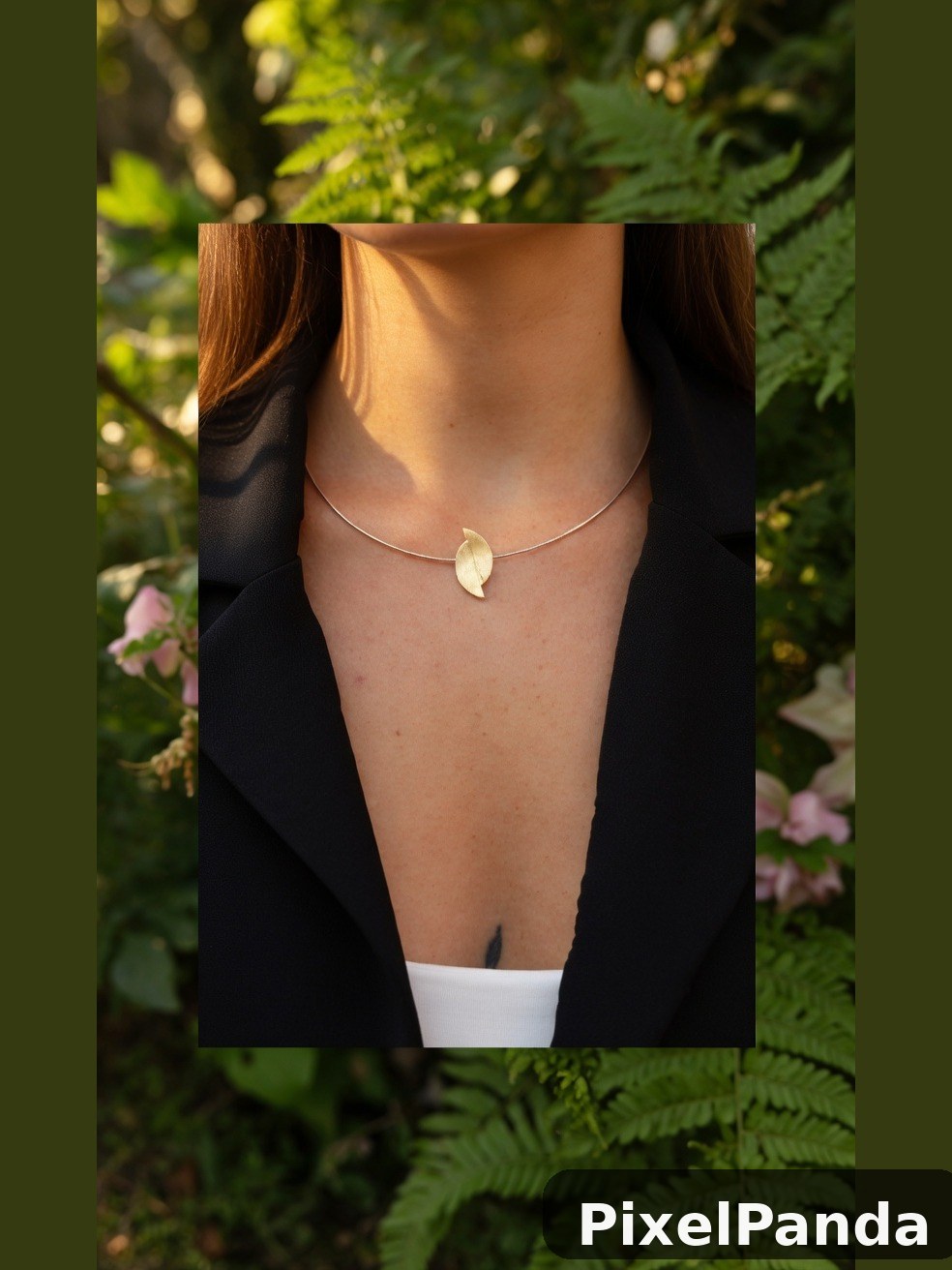 Woman wearing delicate leaf pendant necklace in garden